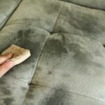 A close-up of fabric being cleaned to remove mold using natural remedies