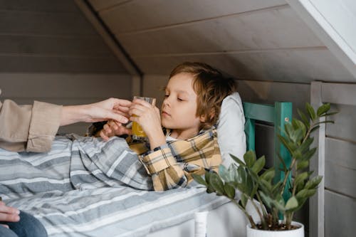 Sick boy lying in bed, highlighting the importance of rest