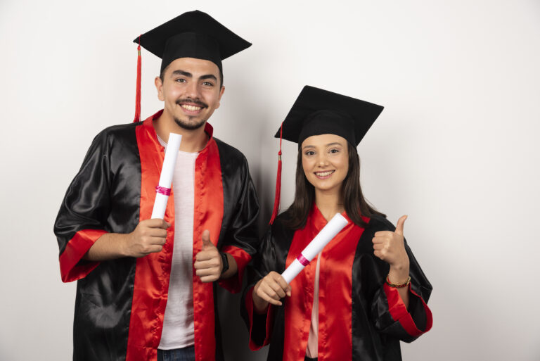 Fresh graduates with diploma making thumbs up on white background