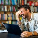 Excited man celebrating success, reading good news in email