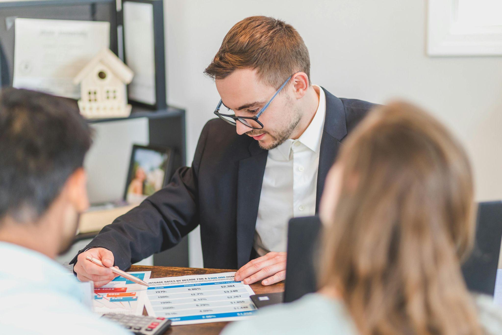 A real estate agent meets with clients to discuss details.