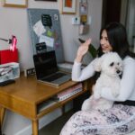 A person with a dog in their lap in front of a ringlight