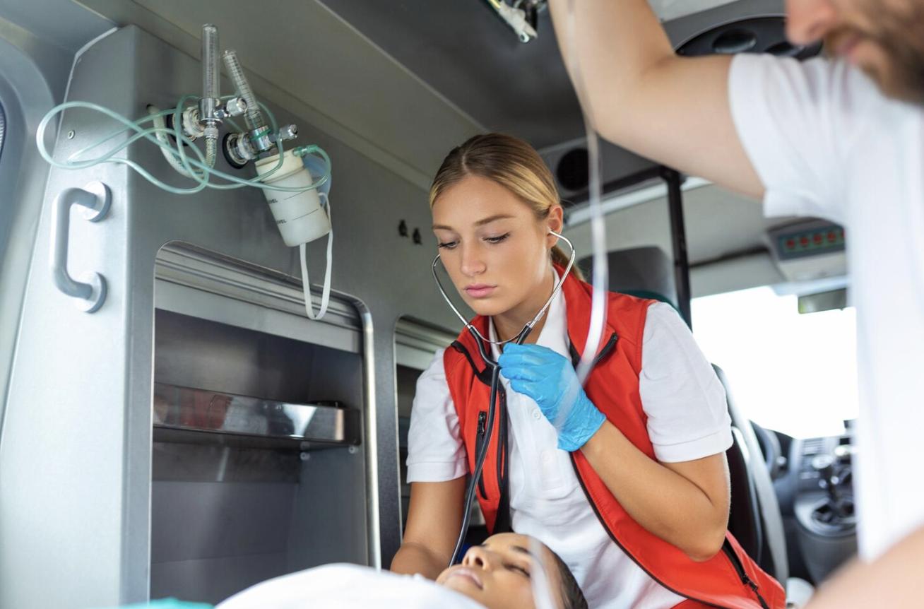 An EMT providing care to a patient in the back of an ambulance