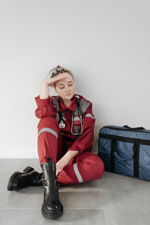EMT in uniform sitting on the floor during a break while on duty