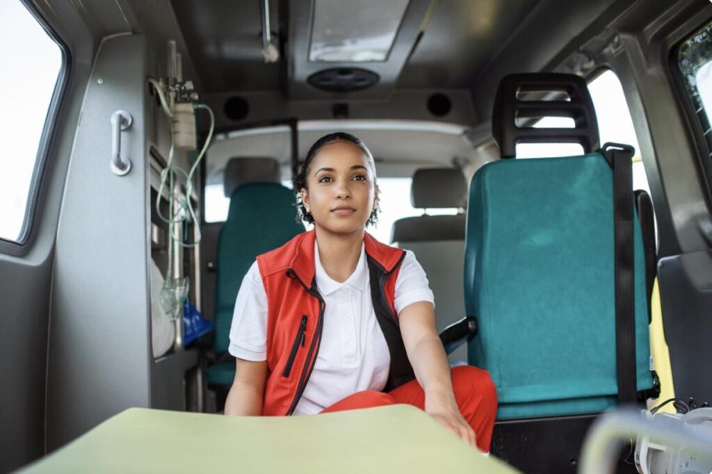 EMT sitting inside an ambulance preparing for patient care