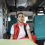 EMT sitting inside an ambulance preparing for patient care