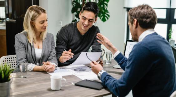 Young couple reviewing mortgage documents with a real estate agent
