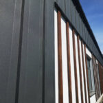 An industrial building featuring silver corrugated metal cladding, professionally installed by metal cladding contractors London to provide a weather-resistant and durable exterior finish.