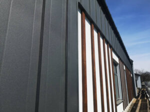 An industrial building featuring silver corrugated metal cladding, professionally installed by metal cladding contractors London to provide a weather-resistant and durable exterior finish.