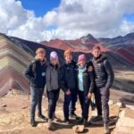 a group of people trekking up the Rainbow Mountains and posing for a picture