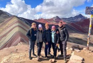 a group of people trekking up the Rainbow Mountains and posing for a picture