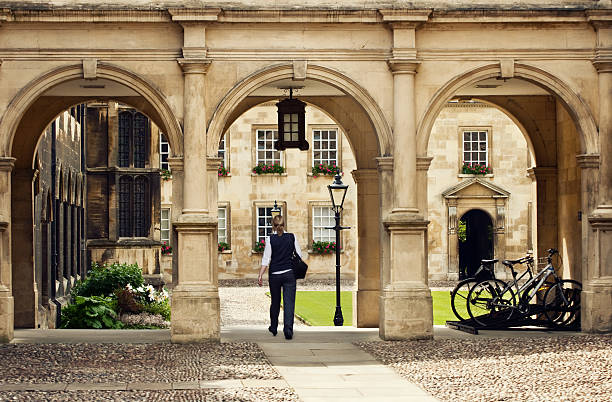 A student walking through a historic stone archway at a traditional British campus, illustrating the successful placement services provided by UK University Admission Consultants.