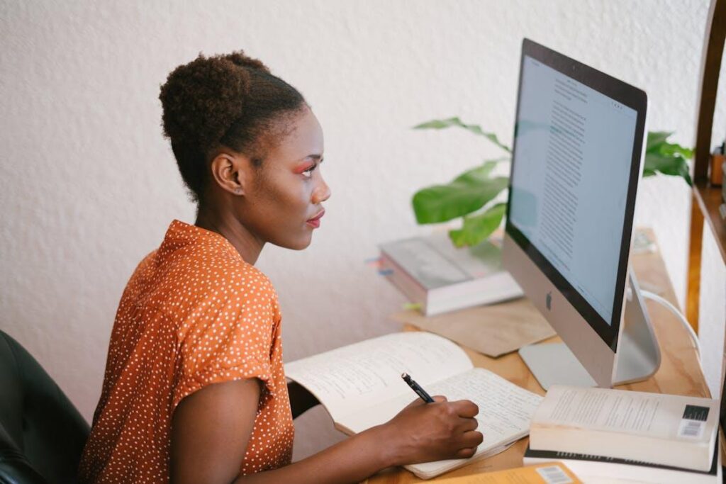 Woman studying on a laptop with NREMT exam materials