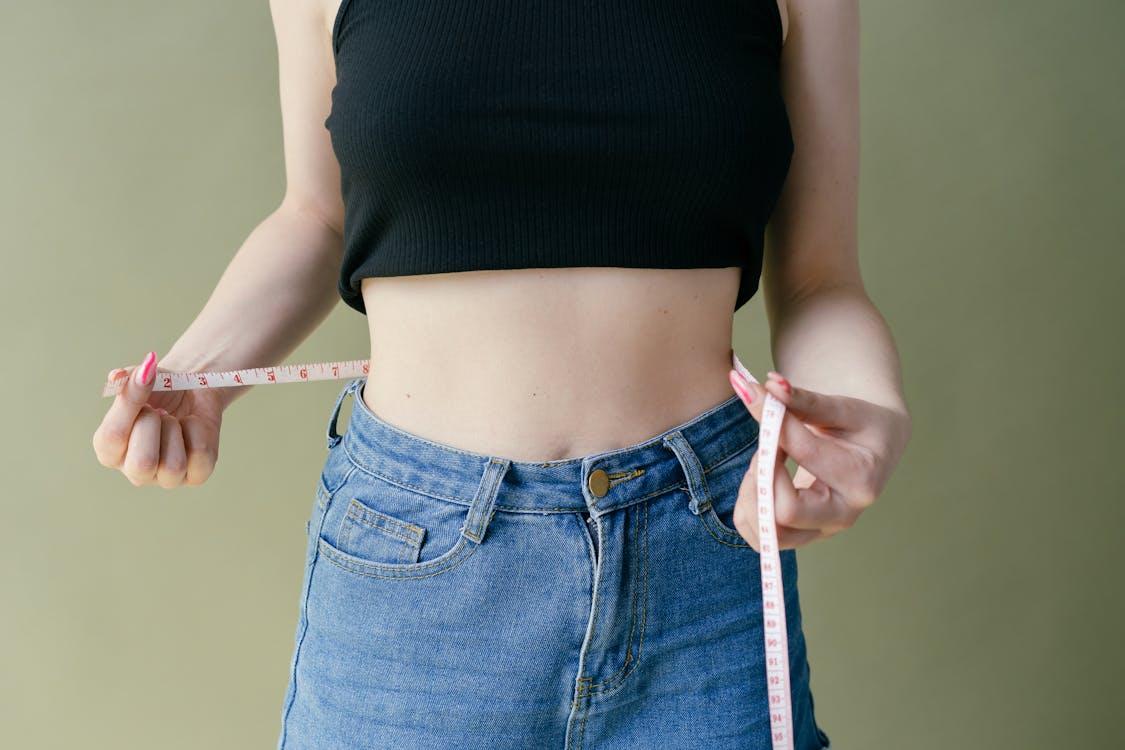 A person measuring their waist 