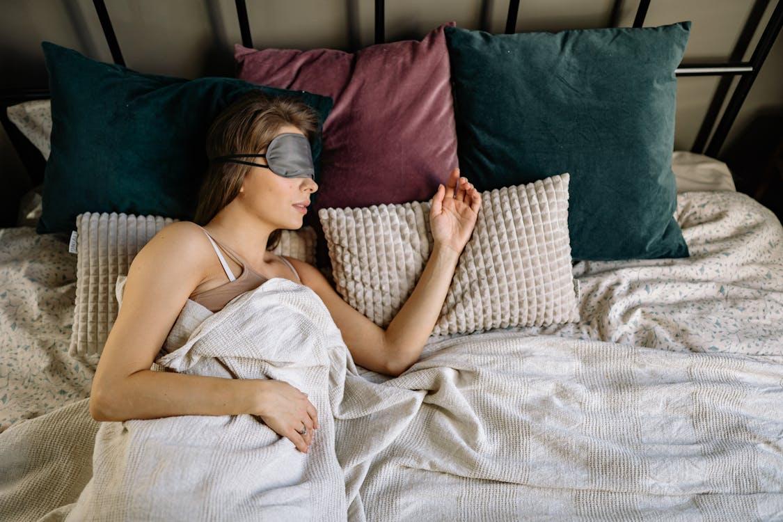 A woman lying in bed wearing a sleep mask
