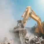 A heavy-duty yellow excavator clearing debris on a residential site, representing professional demolition contractors London services for safe and efficient building removal.
