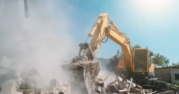 A heavy-duty yellow excavator clearing debris on a residential site, representing professional demolition contractors London services for safe and efficient building removal.