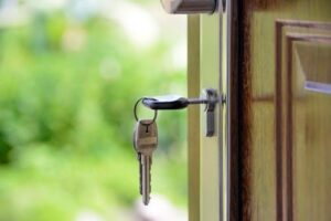 Front door of a house with keys in the lock.