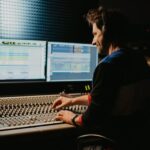 A person with headphones controlling audio equipment