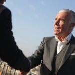 An experienced real estate investor shaking hands with a lending partner