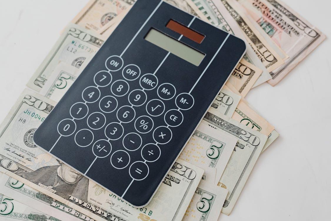 Close-up of banknotes under a calculator, representing financial analysis and recovery tracking for insurance subrogation services