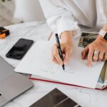 An image of a woman writing something on white paper
