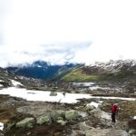 Tourist walks across the snow in the mountains