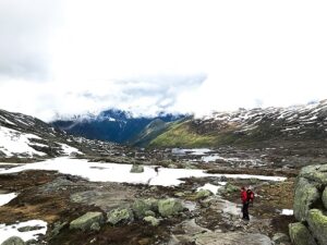 Tourist walks across the snow in the mountains