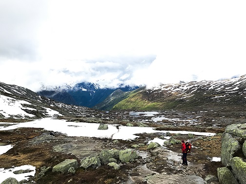 Tourist walks across the snow in the mountains