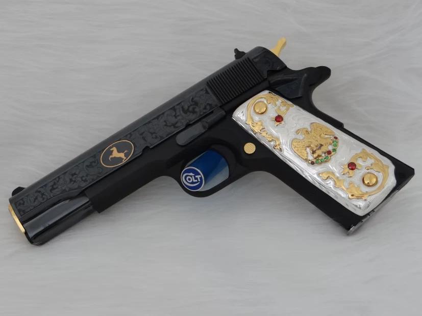 Black customized firearm featuring gold and silver decorative accents with detailed engraving work