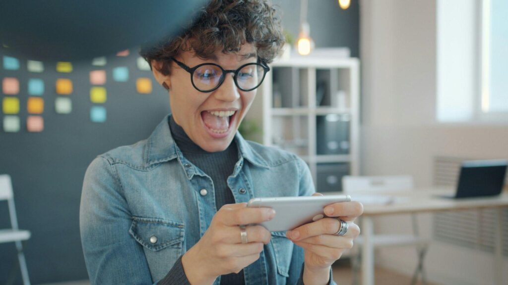 A player excitedly playing a game on her phone