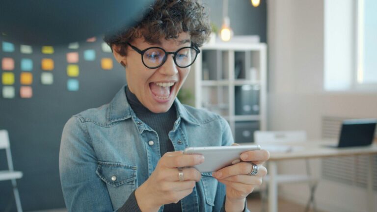 A player excitedly playing a game on her phone