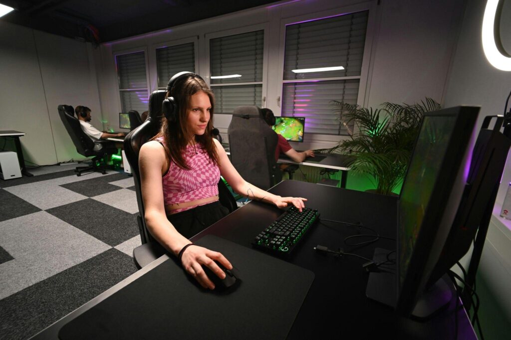 A player focused on gameplay on their computer
