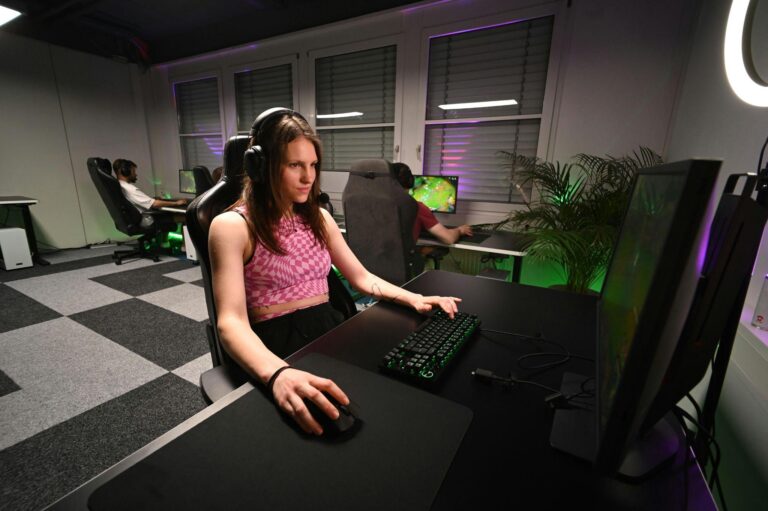A player focused on gameplay on their computer