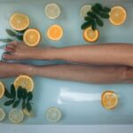 A person in a bathtub filled with orange slices.