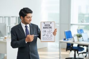 imgi_7_man-suit-standing-office-with-clipboard-pointing-poster-with-words_1098-17121
