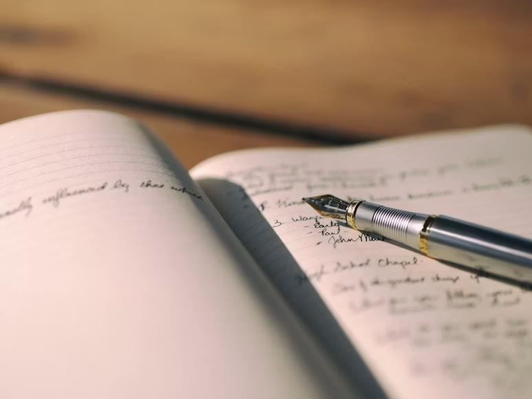 An image of a pen over a journal