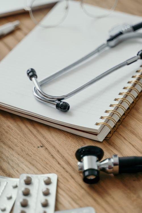 An image of a doctor’s notebook with a stethoscope and medicines