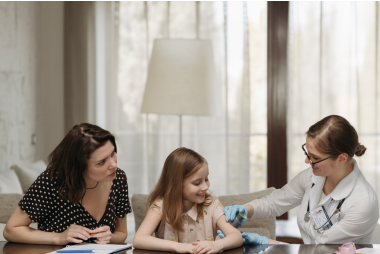 An image of a doctor and mother with a young girl