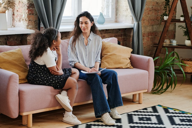 a teen sitting with a caregiver.