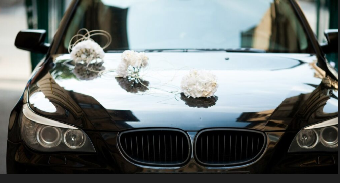A black colored car meant for wedding transportation. 