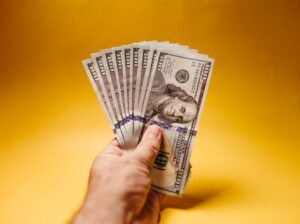 A hand holding US dollar bills