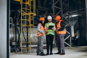 imgi_13_three-factory-workers-safety-hats-discussing-manufacture-plan_1303-30640