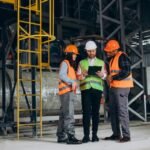 imgi_13_three-factory-workers-safety-hats-discussing-manufacture-plan_1303-30640
