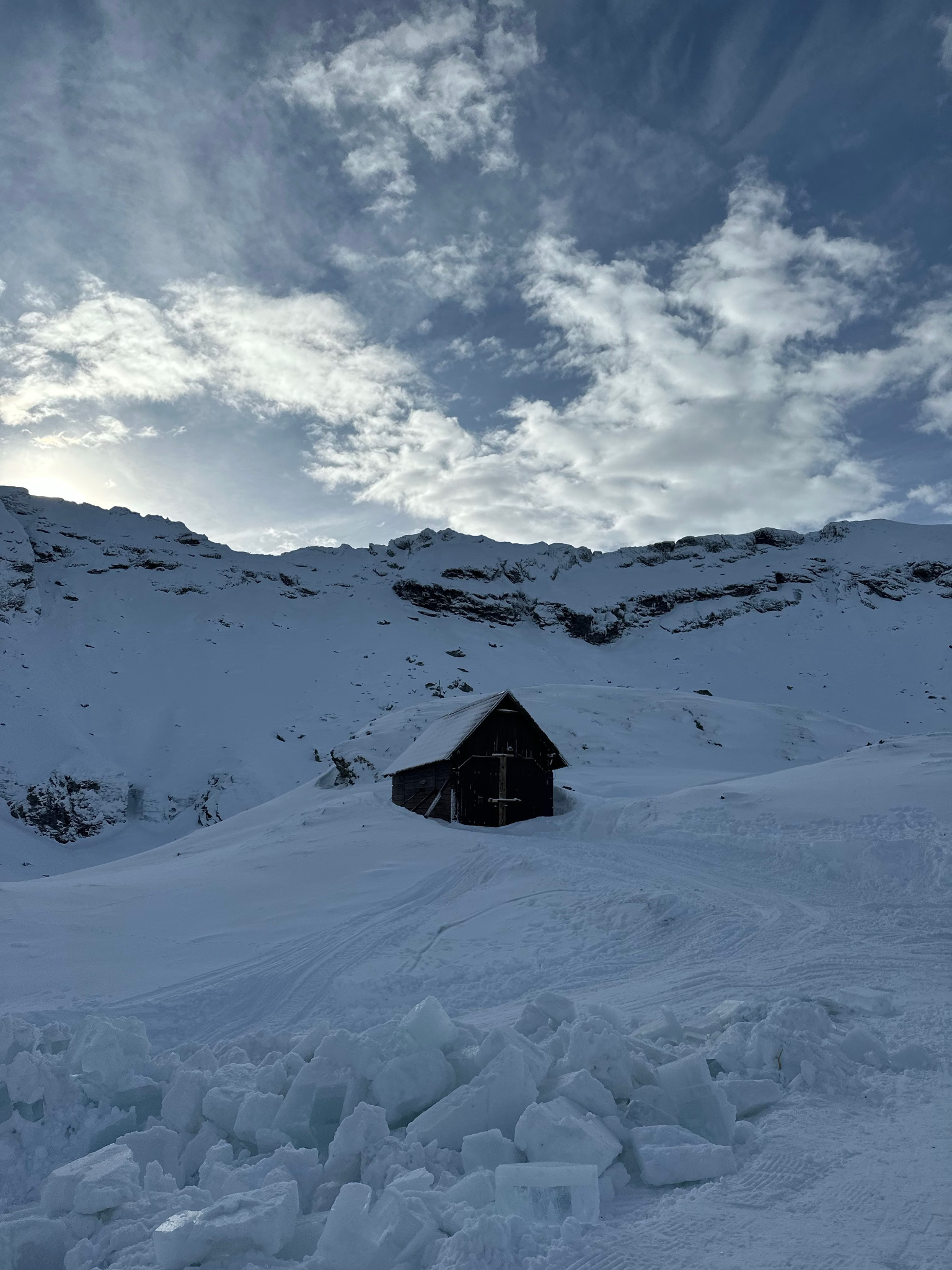 isolated cabin surrounded by snowy mountains