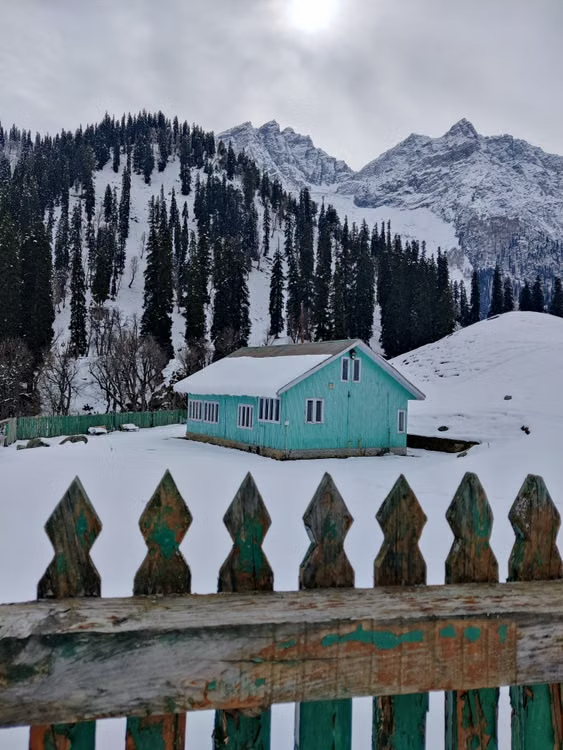wooden house standing alone on a snowy mountain
