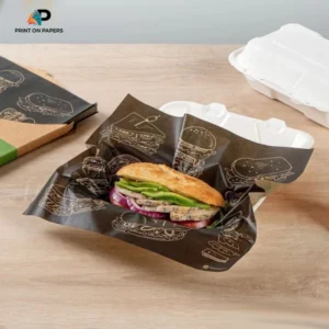 Custom printed black food wrapping paper with a sandwich, branded burger illustrations, and food packaging containers by Print On Papers.