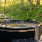 A hot tub set in a quiet backyard surrounded by trees