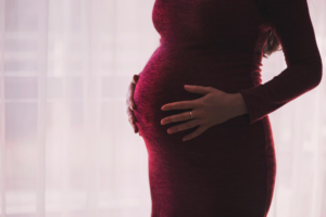 A pregnant person holding their baby bump