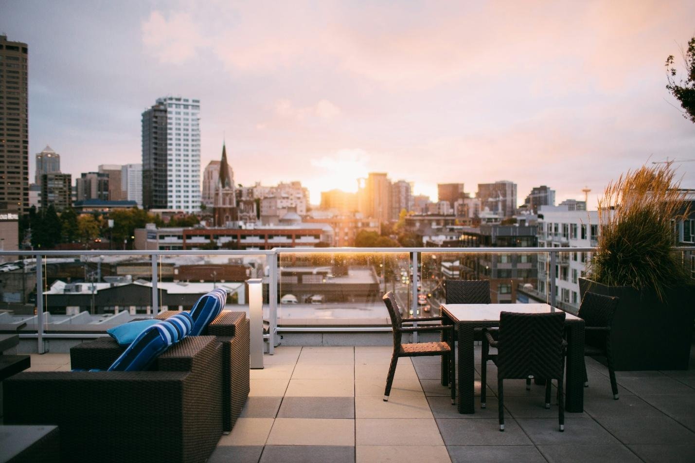 A rooftop terrace lounge area overlooking a city skyline